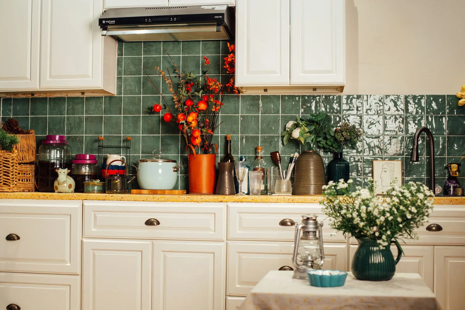 12 Green Kitchen Ideas That Feel Fresh and Modern A warm kitchen interior featuring a green tiled backsplash and various kitchenware for a homely feel.