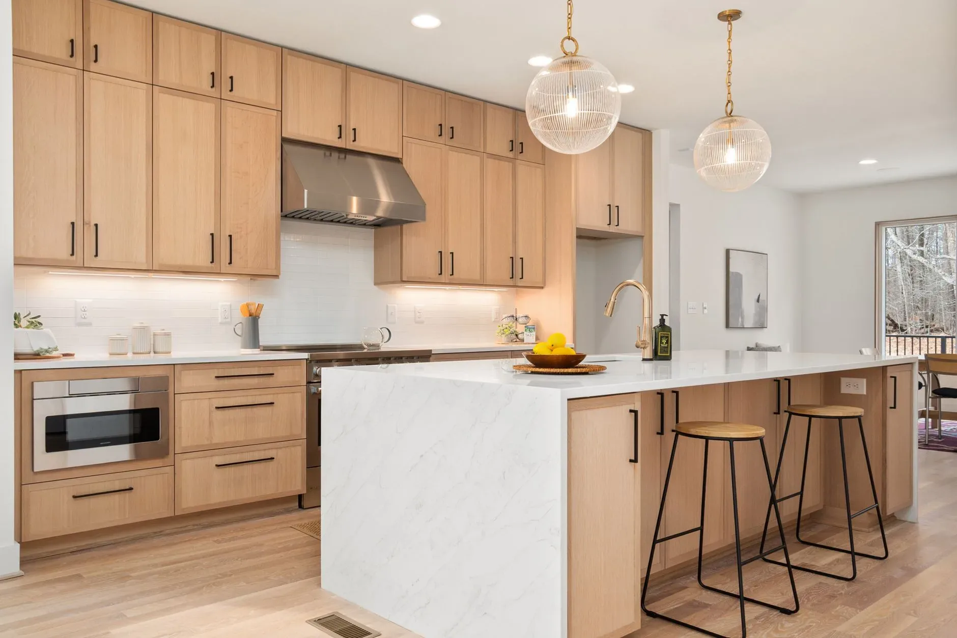15 Wood Kitchen Ideas That Bring Warmth and Character to Any Home Bright modern kitchen with wood cabinets, marble island, and pendant lights, epitomizing Scandinavian design.