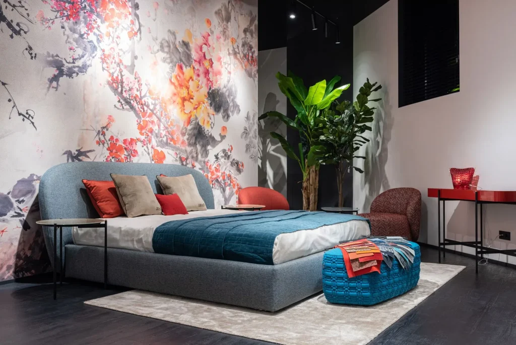 12 Wall Decor Ideas That Turn Every Blank Wall Into Something Beautiful Comfortable bed with colorful cushions and blue blanket placed at painted wall in modern bedroom with armchairs and potted plant