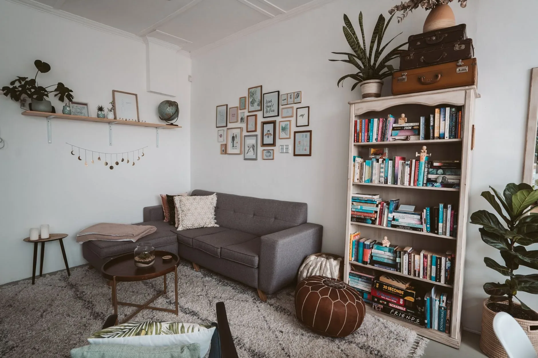 15 High-End Living Room Ideas for Small Spaces Comfortable living room with a modern sofa, bookshelf and decorative plants.