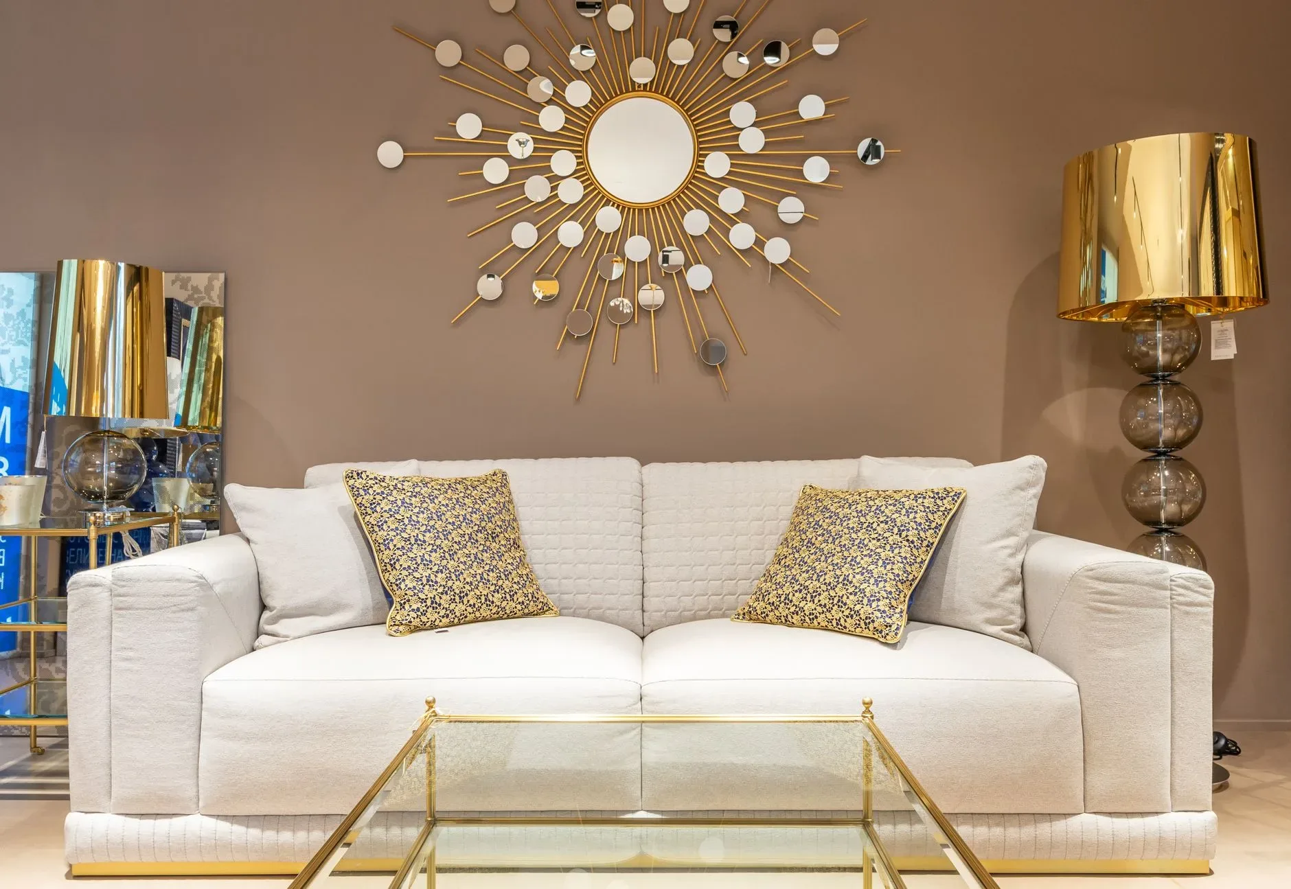 12 Wall Decor Ideas That Turn Every Blank Wall Into Something Beautiful Comfortable white sofa with pillows placed near with floor lamp at wall with decorative elements in stylish living room of apartment