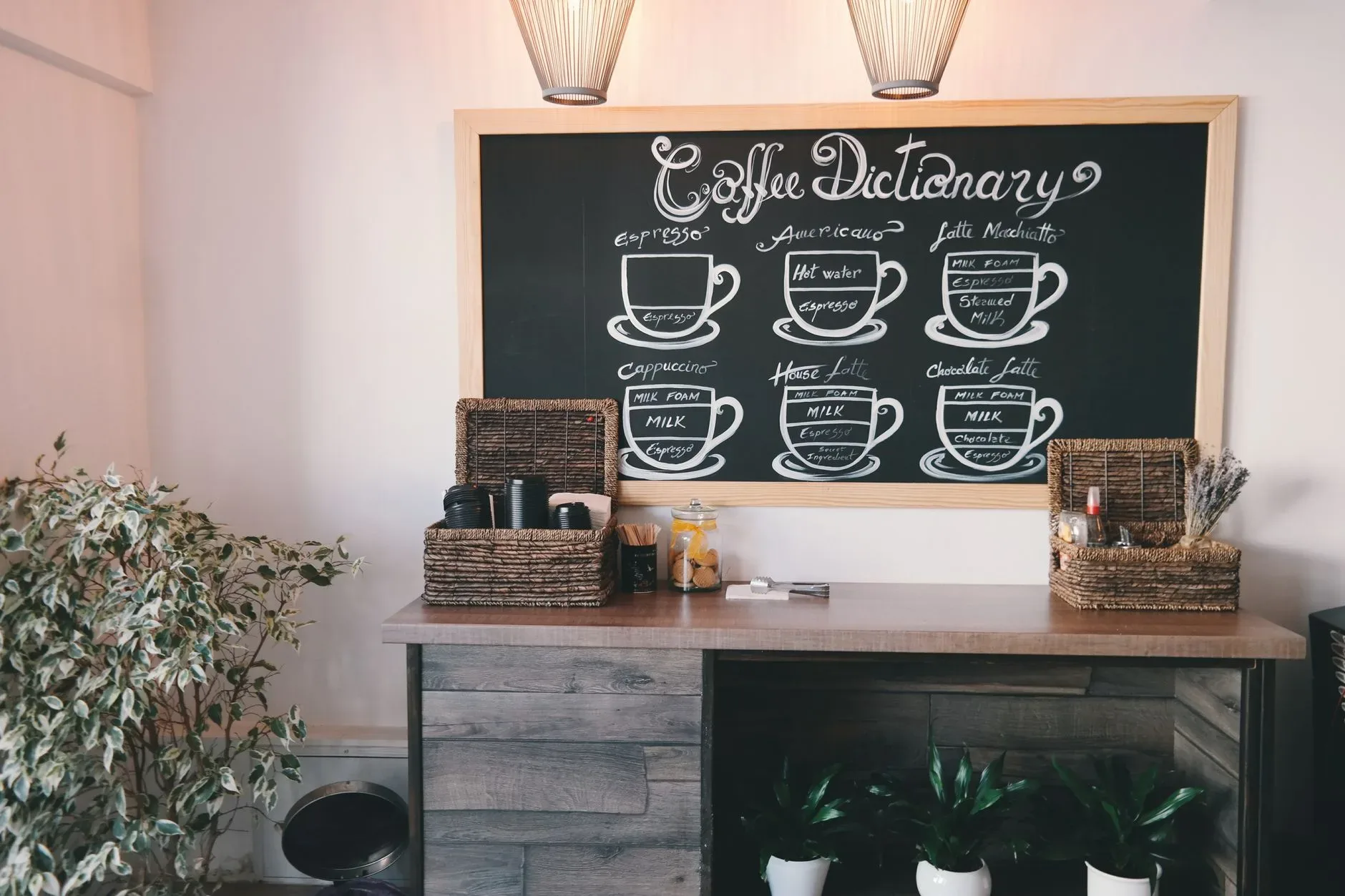 20 Cozy Kitchen Ideas That Make Cooking Feel Like the Best Part of Your Day Cozy coffeehouse interior featuring a stylish chalkboard menu, wicker baskets, and lush indoor plants.
