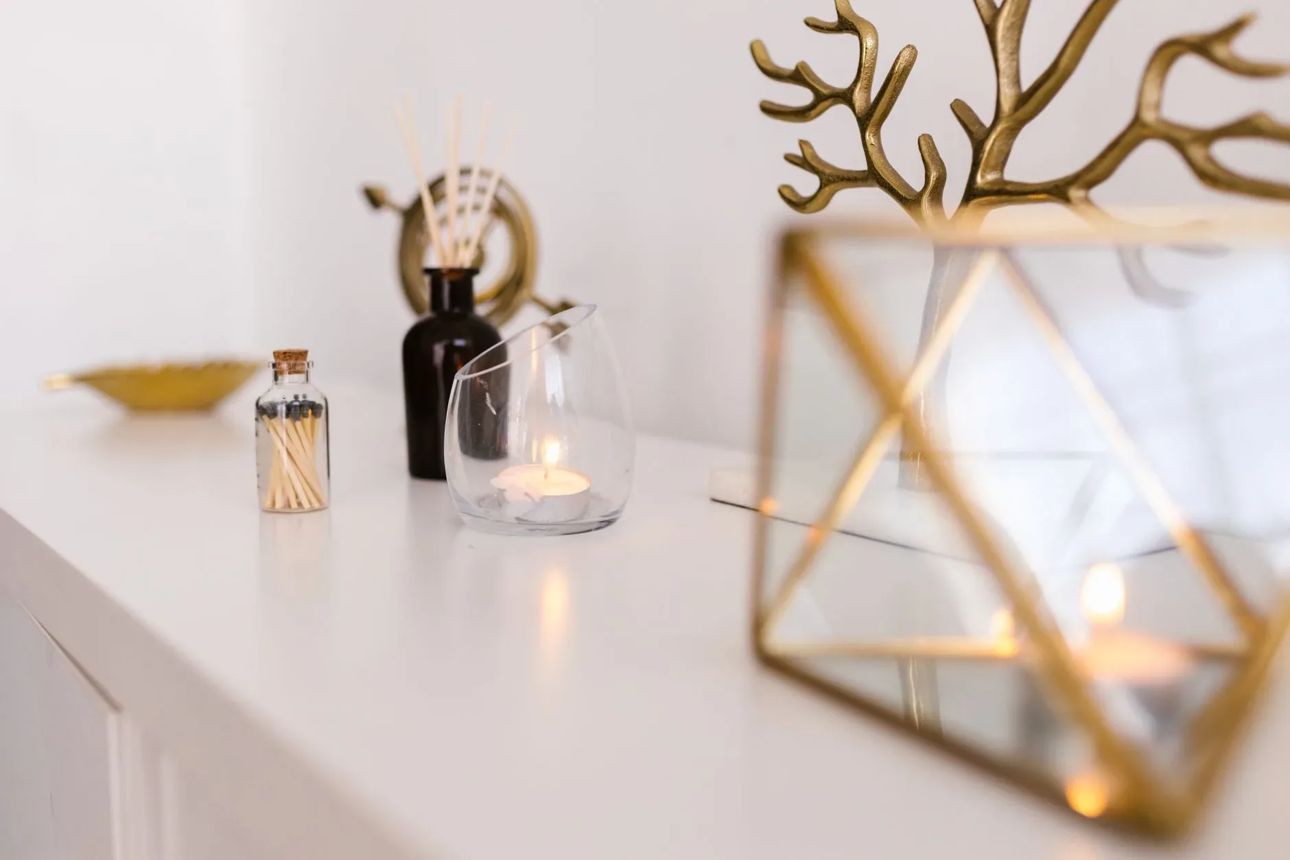18 Cozy Kitchen Decor Ideas for a Warm Home Minimalist arrangement featuring a candle, glass vase, and modern decor on white surface.