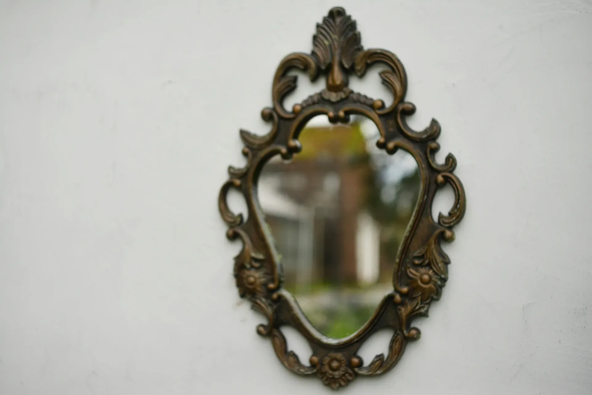 Ornate antique mirror hanging on a white wall