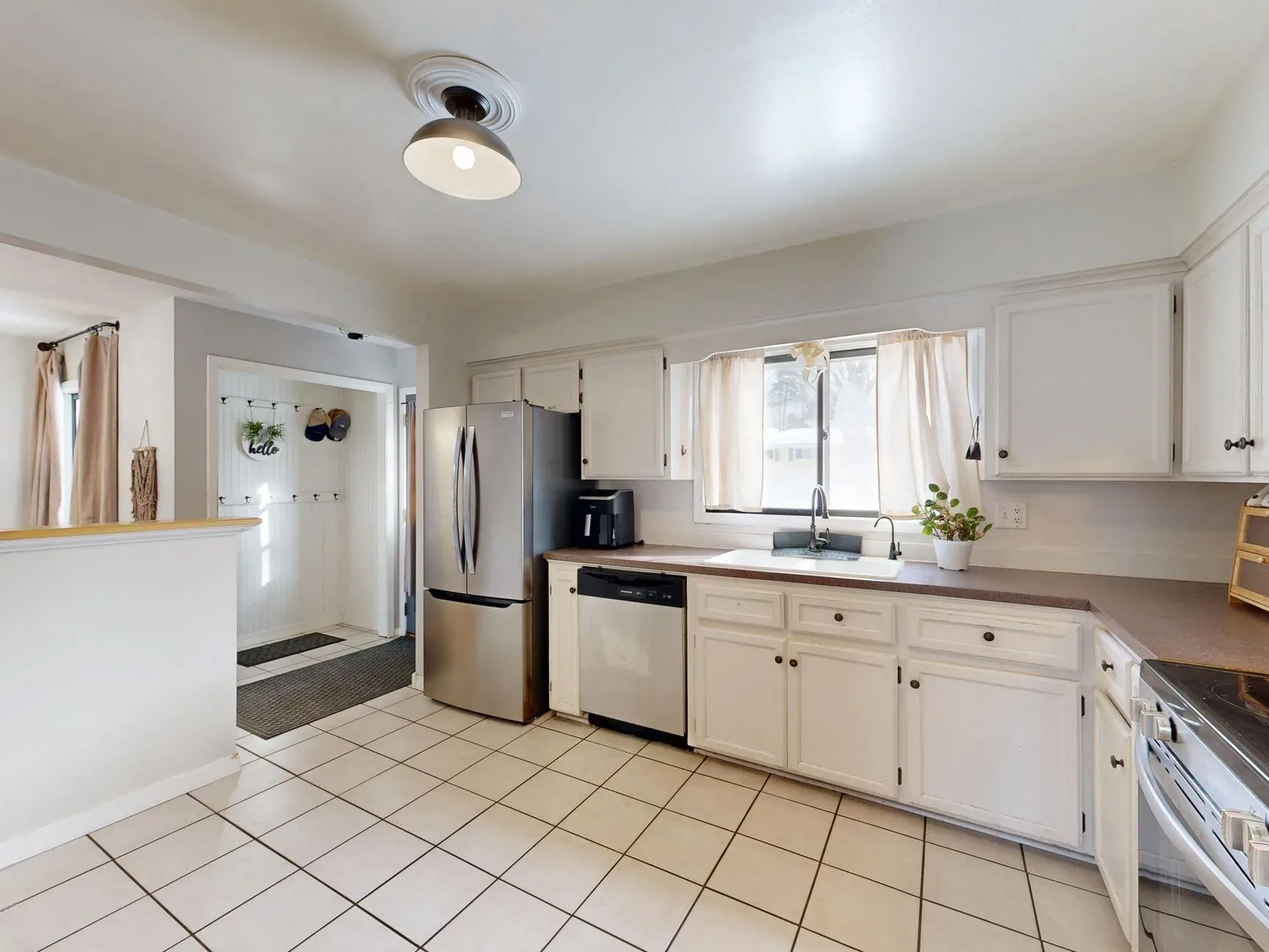 20 Cozy Kitchen Ideas That Make Cooking Feel Like the Best Part of Your Day Spacious kitchen featuring white cabinets and stainless steel appliances, perfect for home cooking.