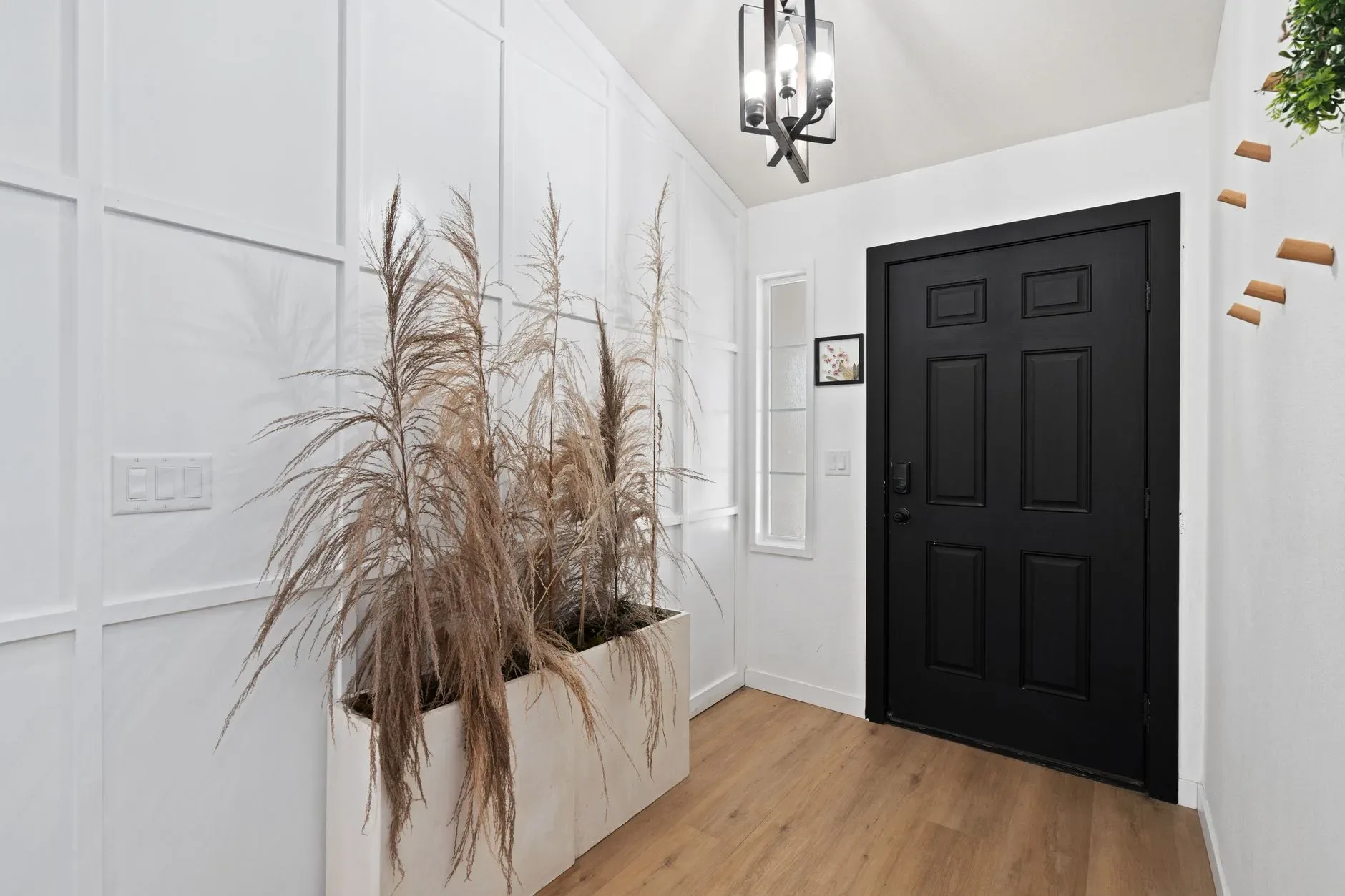 15 White Bathroom Aesthetic Ideas on a Budget Stylish entrance with minimalist decor and modern design featuring a black door.