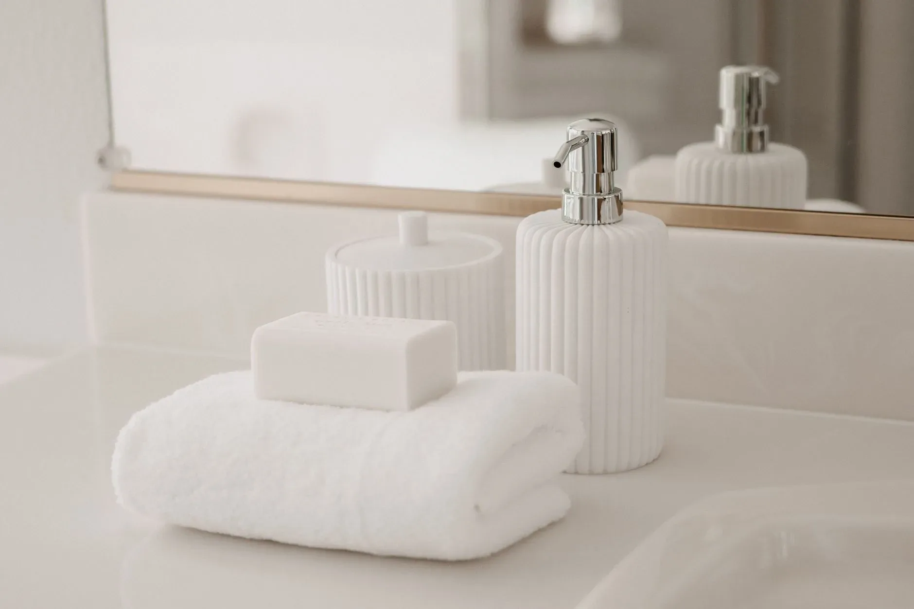 15 White Bathroom Aesthetic Ideas on a Budget Stylish white soap bar and luxury towel arrangement in a modern bathroom setting.