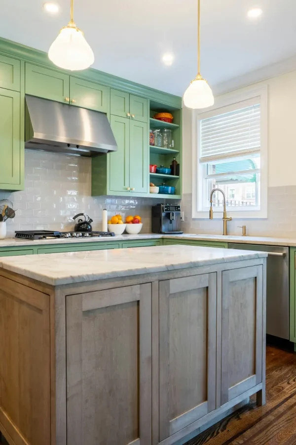 a kitchen with green cabinets and stainless steel appliances