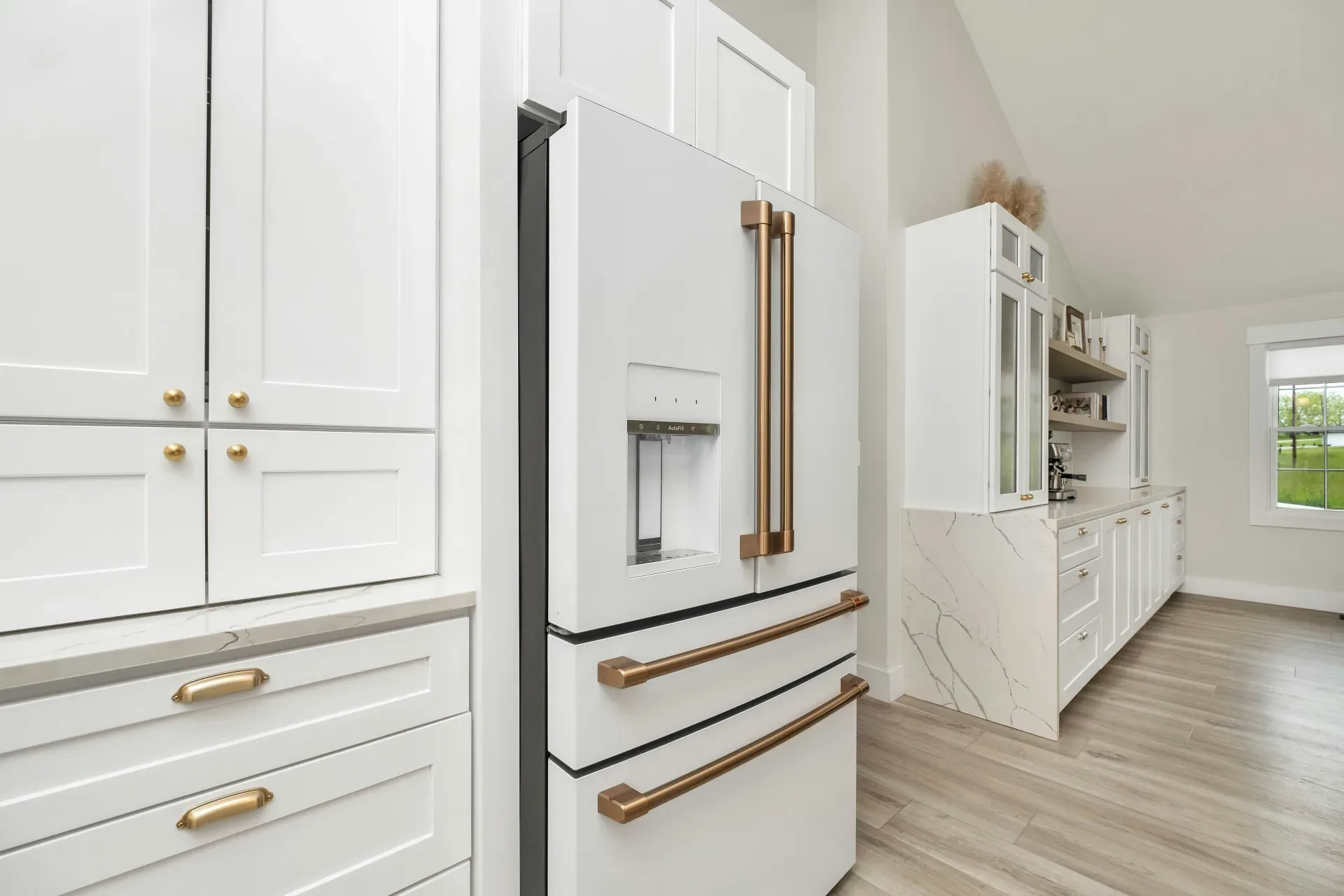 18 Cozy Kitchen Decor Ideas for a Warm Home a kitchen with white cabinets and gold handles